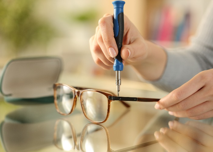 Woman hands tightening screw on glasses with screwdriver